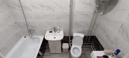 Квартиры Semey في سيمي: حمام مع حوض ومرحاض وحوض استحمام