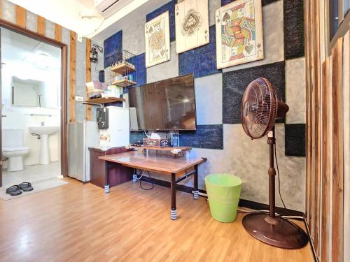 a room with a desk with a fan and a bathroom at 一中喵喵 有統編收據 禁菸 非自助 in Taichung