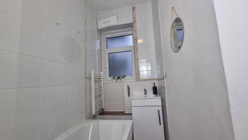 a bathroom with a tub and a sink and a mirror at 3 bed flat O2 arena Dyson house in London