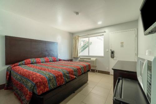 1 dormitorio con cama, escritorio y ventana en Xpress Inn & Extended Stay, en Marshall