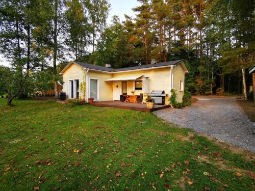 a small white house with a large yard at Hide in the nature – cozy lakeside saunacottage in Rannaküla