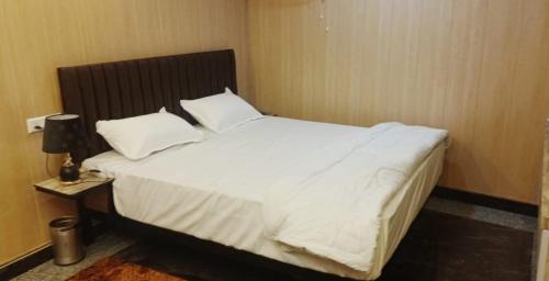 1 dormitorio con 1 cama grande con sábanas y almohadas blancas en DBR GUEST HOUSE en Gorakhpur