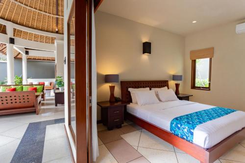 a bedroom with a bed and a living room at The Mutiara Jimbaran Boutique Villas in Jimbaran