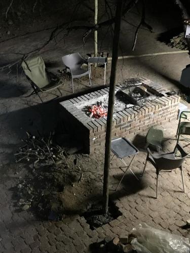 a brick fire pit with chairs and a table at Kruger Wild Dog Inn in Marloth Park