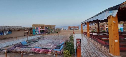 a group of buildings with lots of chairs and tables at Green Beach Camp & Hotel in Nuweiba