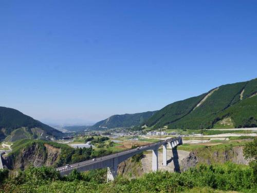 a bridge over a river with a train on it at Aso Canyon Terrace & Lodge in Minami Aso