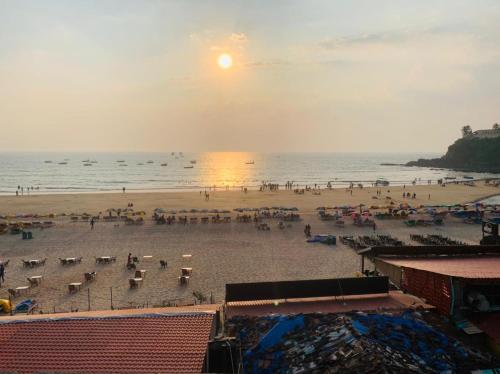 a beach with a crowd of people and the ocean at Baga Beach Sunset in Baga