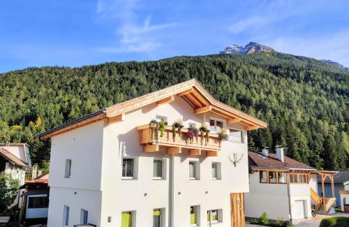 a building with a balcony with a mountain in the background at DMG - 'Large, Luxurious Ground Floor' Apartment in Fulpmes