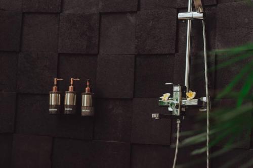 baño con ducha y 4 botellas en la pared en Amazing 1 Bedroom Villa in Ubud en Ubud