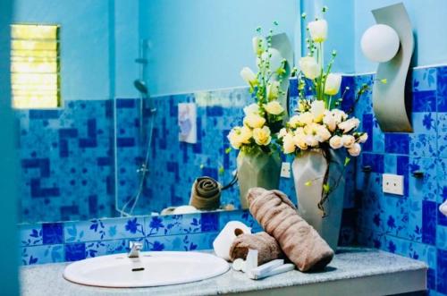 baño con lavabo y jarrón con flores en Spacious House in Talamban, Cebu City, en Cebú