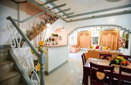 eine Küche und ein Wohnzimmer mit einer Treppe und einem Esszimmer in der Unterkunft Spacious House in Talamban, Cebu City in Cebu City