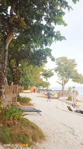 a person walking on a beach near the water at Mactan Newtown Beach Condo in Mactan