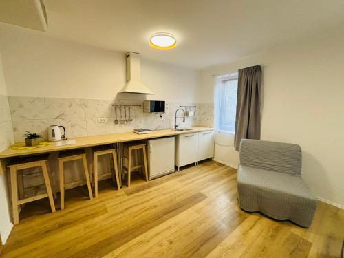 a kitchen with a counter and a table and a chair at Hotel Pohorje in Maribor
