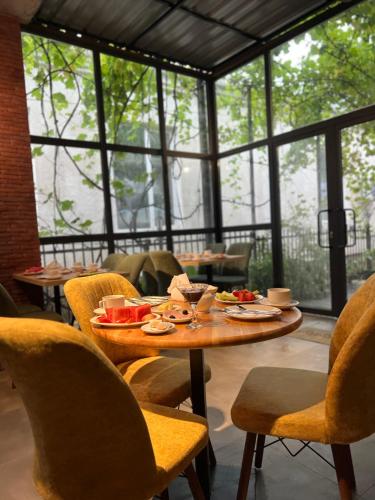 a dining room with a table with food and chairs at Nina two in K'obulet'i