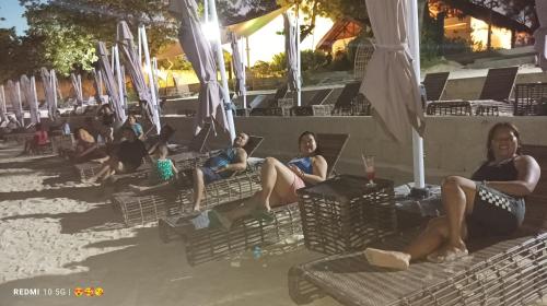 a group of people sitting on chairs at the beach at Mactan Newtown Beach Condo in Mactan