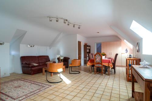 un salon avec un canapé, une table et des chaises dans l'établissement Jacinthe - Appt dans une villa néo-bretonne, à Plomeur