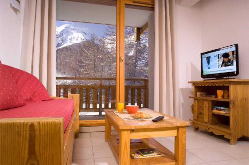 a living room with a view of a snow covered mountain at Madame Vacances Les Balcons Des Airelles in Les Orres