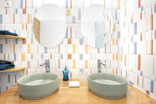 Dos lavabos en un baño con dos espejos en Les Sables D'or - Joli T3 200m de la plage, en Barneville-Carteret