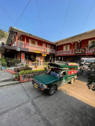a green truck parked in front of a building at Shin Sane Guest House in Mae Salong