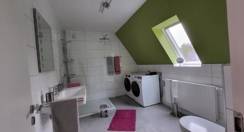 a bathroom with a washing machine and a sink at Ullas Gästehaus in Munster im Heidekreis