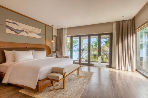 um quarto com uma cama grande e uma janela grande em KOI Resort & Residence Da Nang em Da Nang