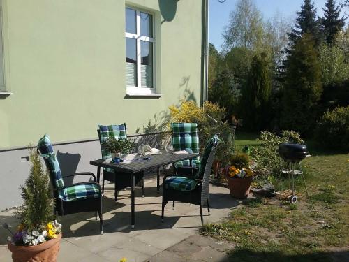 a table and chairs in front of a house at Ferienhaus Emma Ferienwohnung "Paul" in Berndshof