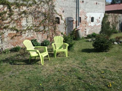 duas cadeiras verdes sentadas na relva num quintal em Ferienhaus Emma Ferienwohnung "Paul" em Berndshof
