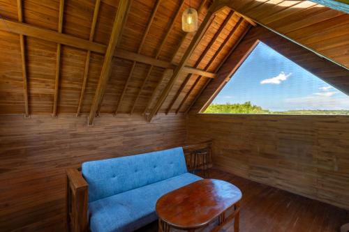 a room with a blue couch and a window at Butterfly Villas Nusa Ceningan in Nusa Lembongan