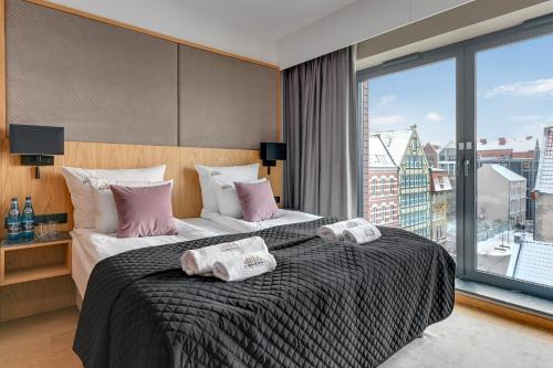 um quarto de hotel com duas camas e uma grande janela em Deo Plaza Riverside & Radisson SPA by Downtown Apartments em Gdansk