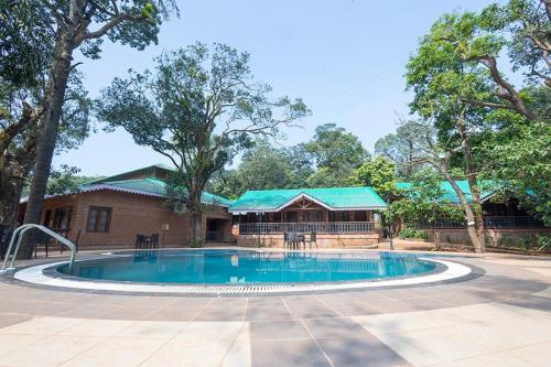una piscina di fronte a una casa con un edificio di Scarlet Resort a Matheran