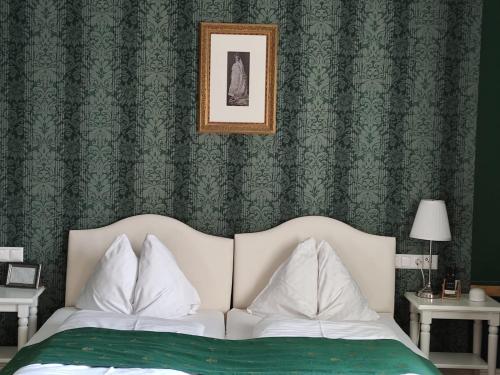 a bedroom with a bed with a green wallpaper at Marius Kammer und Koppel Engelbrecht in Höbersdorf