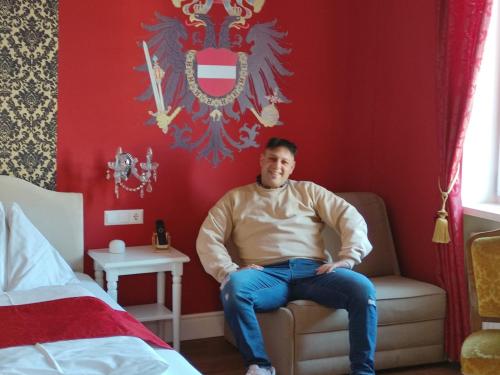 a man sitting in a chair in a bedroom at Marius Kammer und Koppel Engelbrecht in Höbersdorf