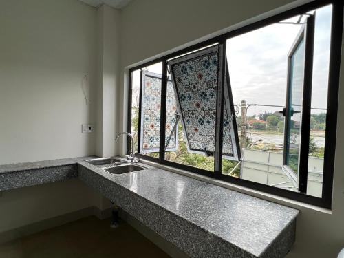 a bathroom with a sink and two windows at Hưng Thành Riverside Hotel in Thái Bình