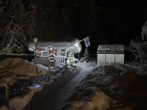 a gingerbread house with christmas lights in a yard at Villa Shaman in Rovaniemi