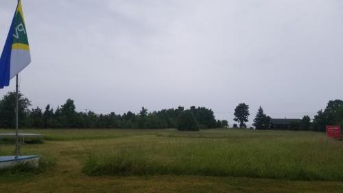 un campo con una bandera en medio de él en Tuuleranna maja ja saun 