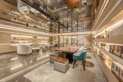 a library with a table and chairs and bookshelves at Atour Hotel Xi'an Chanba Exhibition Center Expo Park in Xi'an