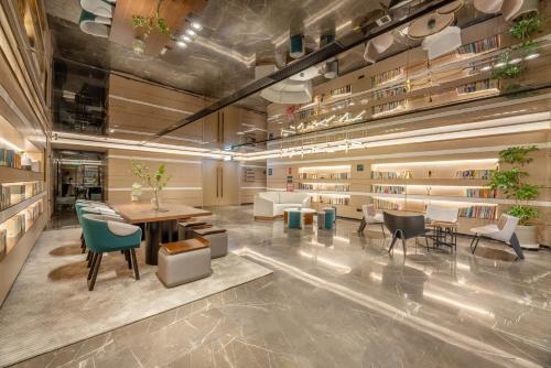 a lobby with tables and chairs in a building at Atour Hotel Xi'an Chanba Exhibition Center Expo Park in Xi'an
