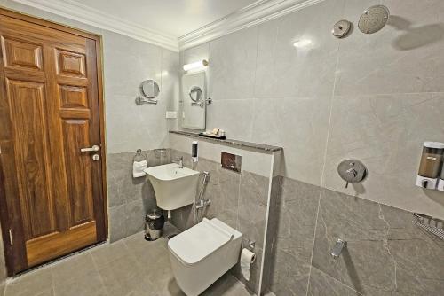a bathroom with a toilet and a sink at Le Colonial Suites in Puducherry