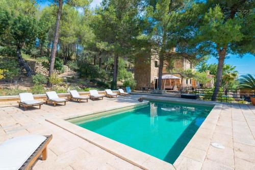 a swimming pool with lounge chairs and a house at Villa Cirera in Alaro in Alaró