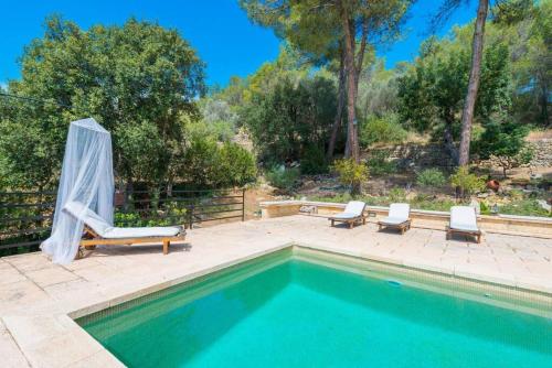 a swimming pool with two lounge chairs next to at Villa Cirera in Alaro in Alaró