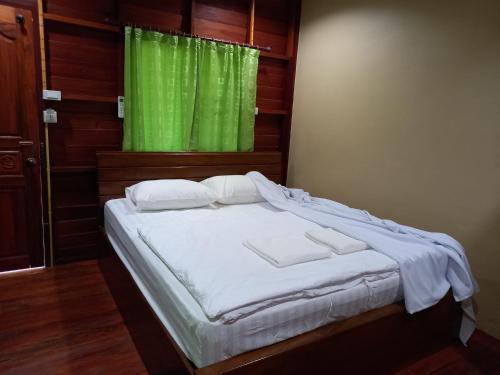 um quarto com uma cama com uma cortina verde em รายานี em Ko Por