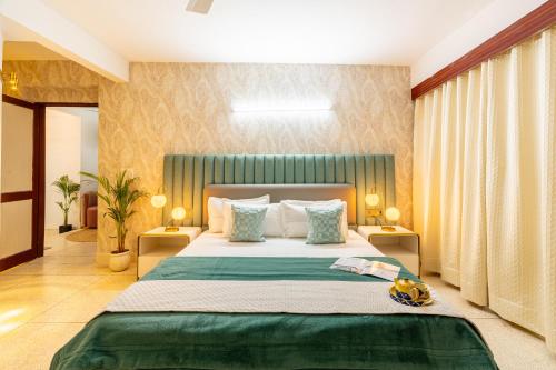 a bedroom with a large bed with a green headboard at Homlee-Excellency 4BHK Apt in South Delhi in New Delhi