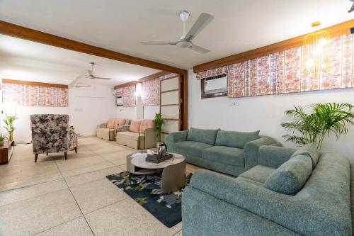 a living room with two couches and a table at Homlee-Excellency Large 4BHK-South Delhi- NFC in New Delhi