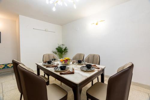 a dining room with a table and chairs at Homlee-Excellency Large 4BHK-South Delhi- NFC in New Delhi