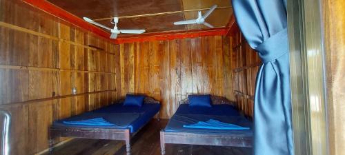 a room with two beds in a wooden cabin at Sea House Guest House in Koh Rong Island