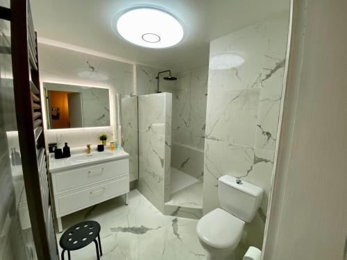 une salle de bain blanche avec des toilettes et un lavabo dans l'établissement Ma place au sud Aix Terrasse Parking, à Aix-en-Provence