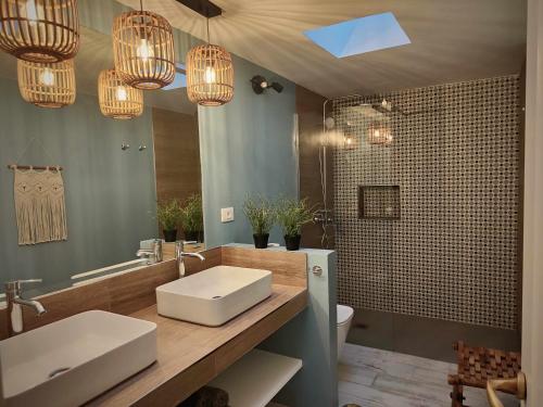 a bathroom with a sink and a mirror and chandeliers at Villa Nuria con piscina privada in Playa del Ingles