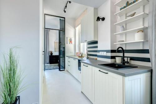 eine Küche mit weißen Schränken und einem Waschbecken in der Unterkunft DR Apartments - Cape in Sopot