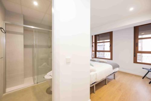 ein Schlafzimmer mit einem Bett, einer Dusche und einem WC in der Unterkunft Apartamentos turísticos Plaza sevillano in Cartagena