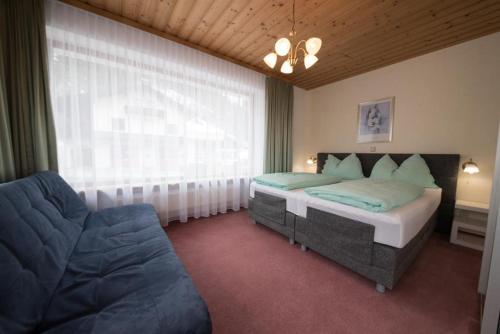 um quarto com 2 camas, um sofá e uma janela em Appartementhaus Renate Unterer em Kelchsau